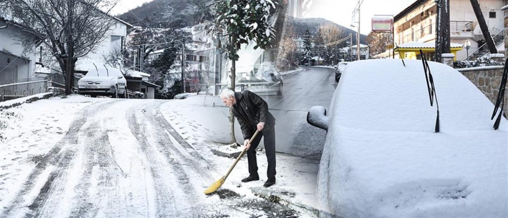 Άνδρας καθαρίζει το χιόνι μετά την επέλαση της κακοκαιρία «Λέανδρος»